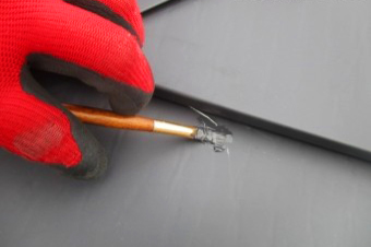 ガルバリウム鋼板屋根の傷を補修する様子